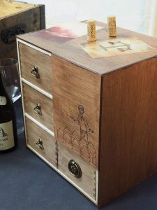 sur un petit meuble à épices avec 4 tiroirs sont déposées de jolies cartes colorées dont une représente une balance