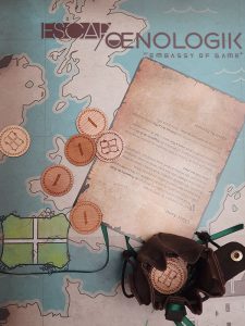 une bourse avec des pièces en bois gravées sont déposées sur le plateau de jeu escap'oenologik