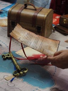 une lettre parchemin tenue par une main féminine une grosse clé ancienne posée tout près