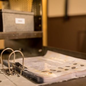 un classeur avec des fichiers d'empreintes posé sur un bureau en fer